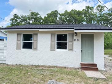 Charming home featuring a tidy front lawn, updated windows with classic shutters and a freshly painted front door at 1921 Nw 12Th St, Ocala, FL 34475