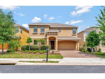 Charming two-story home with a well-maintained lawn, beautiful shrubbery and attached two car garage at 2311 Victoria Dr, Davenport, FL 33837