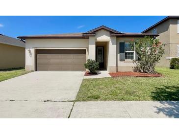 Charming single-story home features an attached two-car garage and manicured landscaping at 254 Alford Dr, Davenport, FL 33896