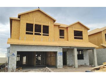 Exterior view of a home under construction with a concrete block first story and plywood second story at 2672 Great Heron Ave, St Cloud, FL 34773