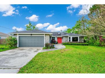Charming home with stone accents, grey garage door, vibrant red door, and a lush green lawn at 275 W 3Rd St, Chuluota, FL 32766