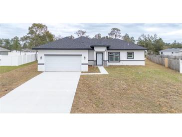 Charming single-story home with a well-manicured lawn, attached garage, and inviting front entrance at 2824 Sw 166Th Ln, Ocala, FL 34473