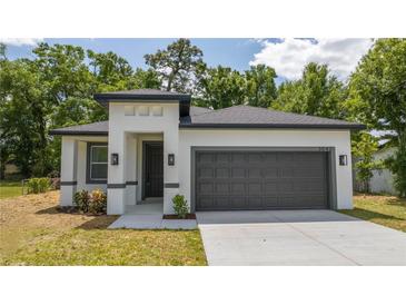 Charming single-story home featuring a gray garage door, neutral paint and a well-maintained lawn and landscaping at 3042 Herold Dr, Orlando, FL 32805