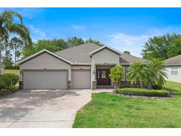 Beautiful single Gathering home with a well-maintained lawn, three-car garage, and a red brick driveway at 3281 Saloman Ln, Clermont, FL 34711