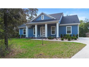 Charming blue home featuring a covered front porch and well-manicured lawn, perfect for curb appeal at 34 Jackson Cir, Winter Springs, FL 32708