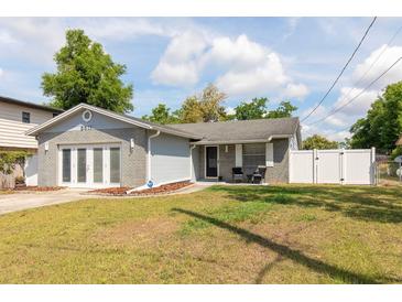 Charming single-story home with a well-manicured lawn, brick facade, and a cozy front porch sitting area at 3511 E Crystal Lake Ave, Orlando, FL 32806
