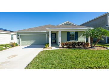 Charming single-story home with a well-maintained lawn, attached garage, and inviting covered porch at 828 Gisele Ct, Haines City, FL 33844