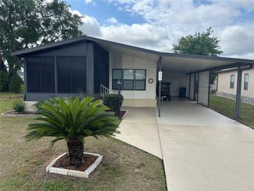 Charming single-story home with a well-maintained lawn, carport, and a screen room at 117 Darlene Ct, Davenport, FL 33897