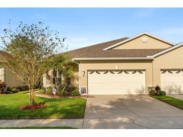 Charming single-story home with a well-maintained lawn and a two-car garage on a sunny day at 122 Lower Lake Ct, Debary, FL 32713