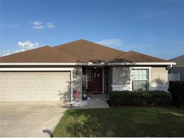 Charming single-story home featuring a well-maintained lawn and a welcoming two-car garage at 1381 Woodlark Dr, Haines City, FL 33844