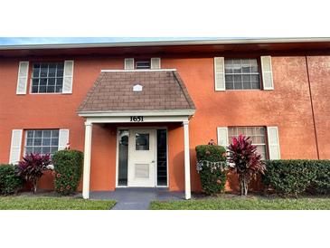 Charming two-story condo featuring a welcoming entrance with decorative landscaping and white trim at 1651 W Oak Ridge Rd # 1651A, Orlando, FL 32809
