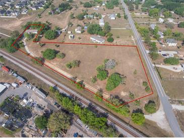 Expansive property featuring a mix of open space, mature trees, and residential structures, conveniently situated near railways at 2300 Olsen Rd, Haines City, FL 33844
