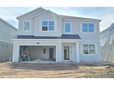 New two-story home featuring an attached two-car garage and white accents against the gray siding at 2666 Great Heron Ave, St Cloud, FL 34773