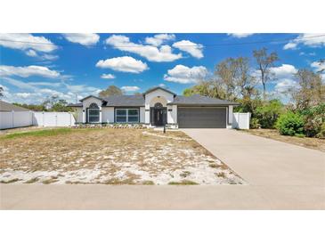 Charming single-story home boasts a two-car garage, neutral paint scheme and well-manicured landscaping at 2685 Groveland Ave, Deltona, FL 32725