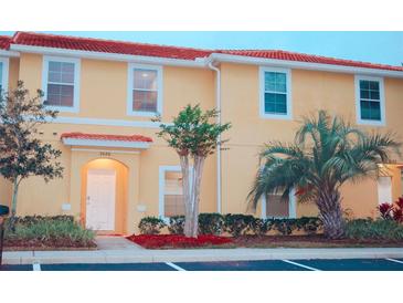 Charming two-story townhome with a red tile roof and well-manicured landscaping at 3020 Red Ginger Rd, Kissimmee, FL 34747
