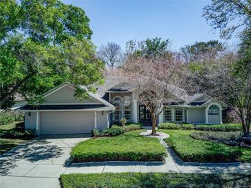 Charming single-story home with mature trees, a well-manicured lawn, and inviting curb appeal at 320 Remington Dr, Oviedo, FL 32765