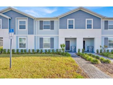 Inviting exterior of a charming townhome with a well-manicured lawn and a welcoming entrance at 3729 Pacific Ln, Davenport, FL 33897