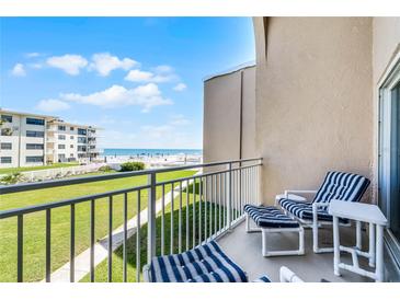 Relax on the balcony with seating and enjoy beautiful views of the ocean and the green lawn at 4821 Saxon Dr # 201B, New Smyrna Beach, FL 32169
