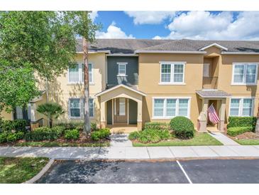 Inviting townhome featuring a beige exterior, manicured landscaping, and an American flag waving near the entrance at 5412 Factors Walk Dr, Sanford, FL 32771