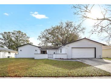 Charming white home with a well-manicured lawn, attached garage, and inviting curb appeal at 621 Ashberry Ln, Altamonte Springs, FL 32714