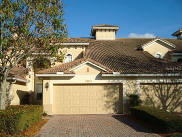 Charming villa with a two-car garage, red-tiled roof, and well-maintained landscaping in a sunny setting at 6240 Miramonte Dr # 102, Orlando, FL 32835