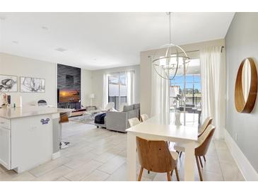 Bright living room with modern finishes, adjacent dining area, and outdoor access at 8969 Stinger Dr, Davenport, FL 33896
