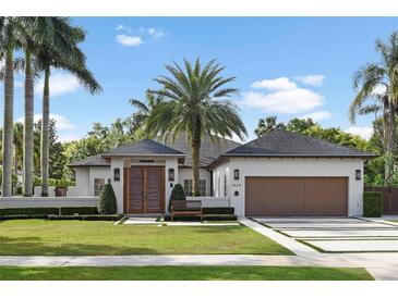Stunning home featuring manicured lawns, a symmetrical facade, and a welcoming driveway framed by lush landscaping at 1020 Mayfield Ave, Winter Park, FL 32789
