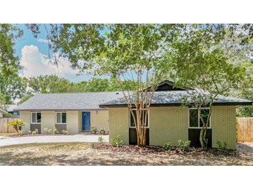 Charming one-story home with a blue front door, landscaped yard, and mature trees creating a welcoming curb appeal at 1025 Winter Springs Blvd, Winter Springs, FL 32708