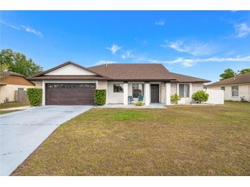 Charming single-story home with a well-maintained lawn, two-car garage, and inviting entryway at 1065 Jason Ridge Ct, Kissimmee, FL 34747