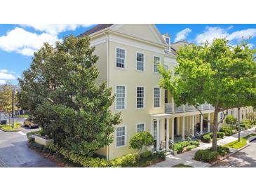 Three-story traditional home with white trim, green trees, and well-kept landscaping at 1425 Chatfield Pl, Orlando, FL 32814