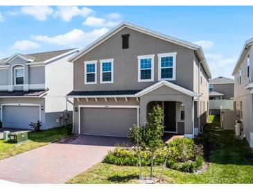 Charming two-story home with a brick driveway, attached garage, and well-maintained landscaping at 14613 Erice Ave, Clermont, FL 34714