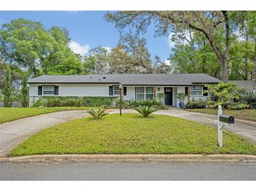 Charming home featuring a well-manicured lawn and a circular driveway, adding to its curb appeal at 1621 Highland Dr, Longwood, FL 32750
