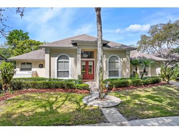 Charming single-story home with manicured landscaping and a bright red front door at 418 Curry Ct, Altamonte Springs, FL 32714