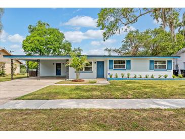 Charming single-story home featuring a well-manicured lawn and blue accent details at 4415 Gilpin Way, Orlando, FL 32812