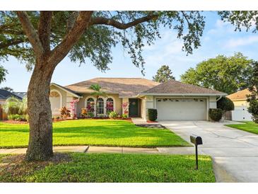 Charming single-story home featuring a well-manicured lawn and colorful flower beds enhancing its curb appeal at 652 Rochester St, Oviedo, FL 32765