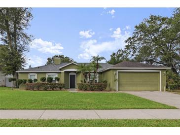 Charming one-story home featuring a well-manicured lawn, and attached two-car garage at 817 Benton Lake S Dr, Deland, FL 32724