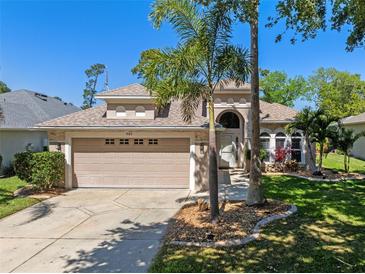Charming single-story home with a well-manicured lawn and mature landscaping, including palm trees at 902 Wingate Trl, Port Orange, FL 32128