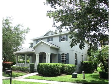 Charming two-story home features a covered porch, manicured landscaping, and classic architectural details at 14522 Old Thicket Trace, Winter Garden, FL 34787