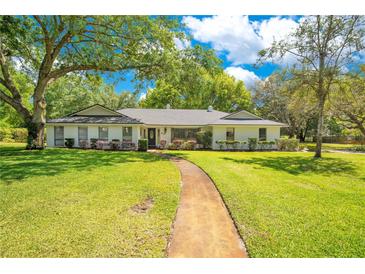 Charming single-story home featuring a large front yard, mature trees and inviting curb appeal at 20 Stone Gate S, Longwood, FL 32779