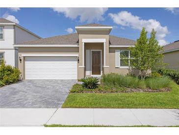 Charming single-story home with a well-manicured lawn, paver driveway, and inviting front entrance at 2030 Firethorn Loop, Haines City, FL 33844