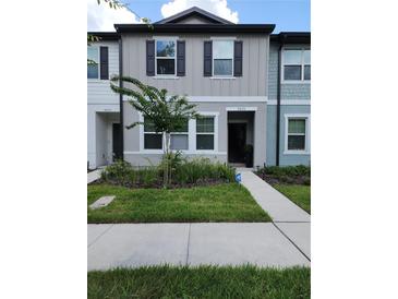 Charming townhome features neutral siding, a well-manicured lawn, and a welcoming entrance for easy access at 3020 Water Sprite St, Orlando, FL 32808