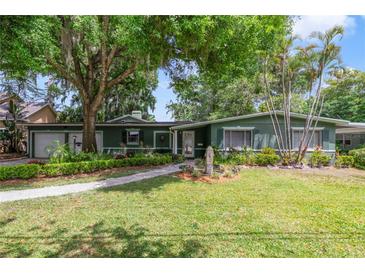 Charming single-story home with lush landscaping, mature trees, and a welcoming front walkway at 3225 Hargill Dr, Orlando, FL 32806