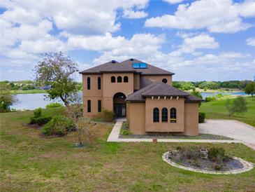 Stunning two-story home with a well-manicured lawn and lake views, perfect for luxurious living at 36813 Barrington Dr, Eustis, FL 32736