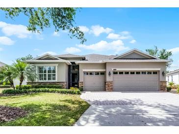 Charming single-story home with a three-car garage, stone accents, and manicured landscaping in a serene setting at 3714 Marigot Way, Clermont, FL 34711