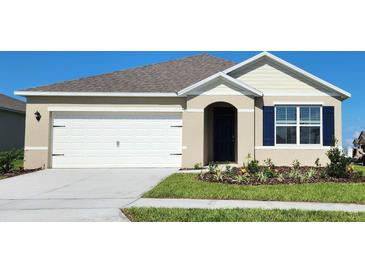 Charming single-Gathering home featuring a two-car garage, manicured lawn and colorful flower beds at 3735 Bluethread Way, Poinciana, FL 34759