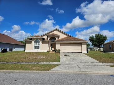 Charming single-story home featuring a two-car garage and well-maintained front lawn under a bright, cloudy sky at 4526 Oakton Dr, Orlando, FL 32818