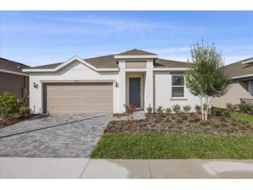 Charming single-story home featuring a two-car garage, manicured landscaping, and a welcoming entrance at 527 Silver Palm Dr, Haines City, FL 33844
