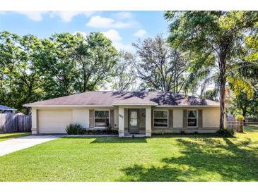 Charming single-story home features a well-manicured lawn and attached garage at 5831 Nw 58Th Ter, Ocala, FL 34482