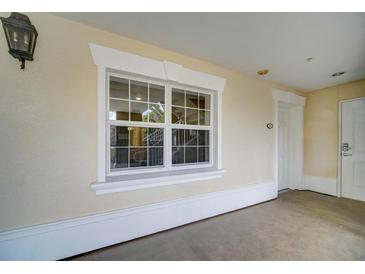 Exterior view showing a large window with white trim and stucco wall under a covered entry at 7651 Whisper Way # 104, Reunion, FL 34747