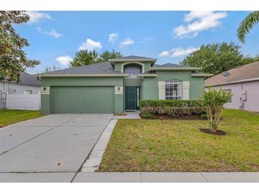 Charming single-Gathering home featuring a well-manicured lawn and an attached two-car garage at 7718 Cafaro Dr, Orlando, FL 32818